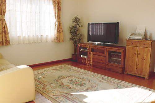 2面採光の日当たり良好なリビング。家具はダイ二ングセットと同じデザインのもので統一されている